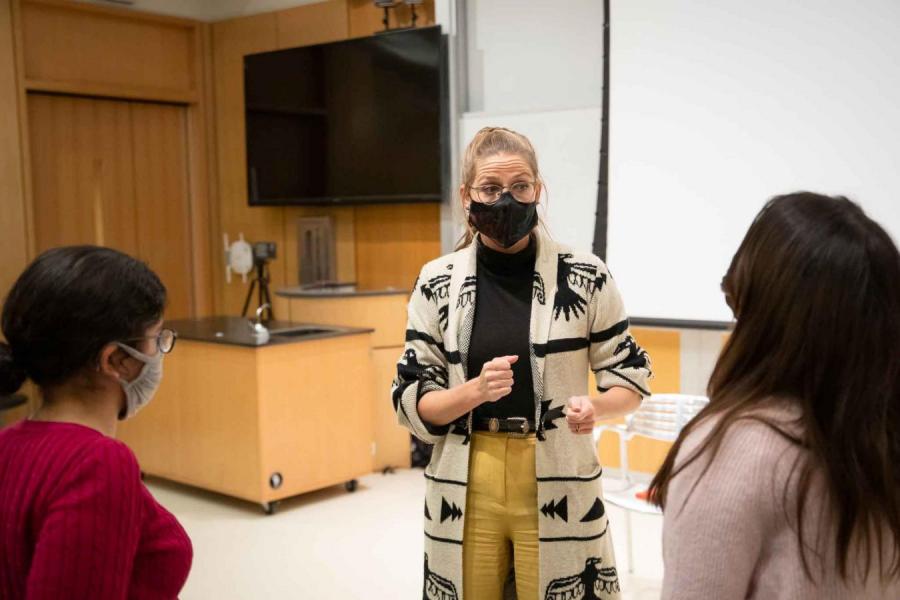 woman talking with two students