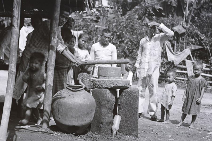 Several people stand near a well
