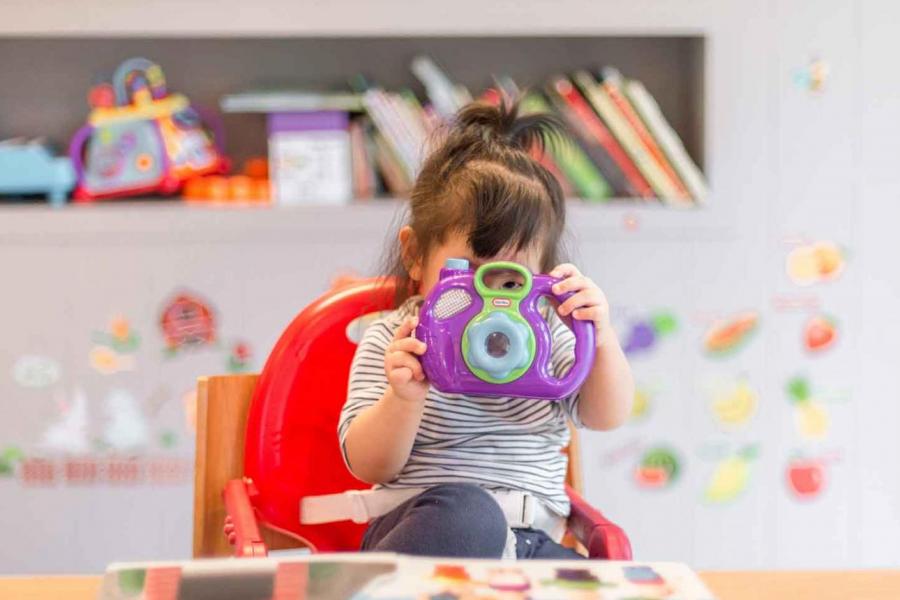 Child holding toy camera