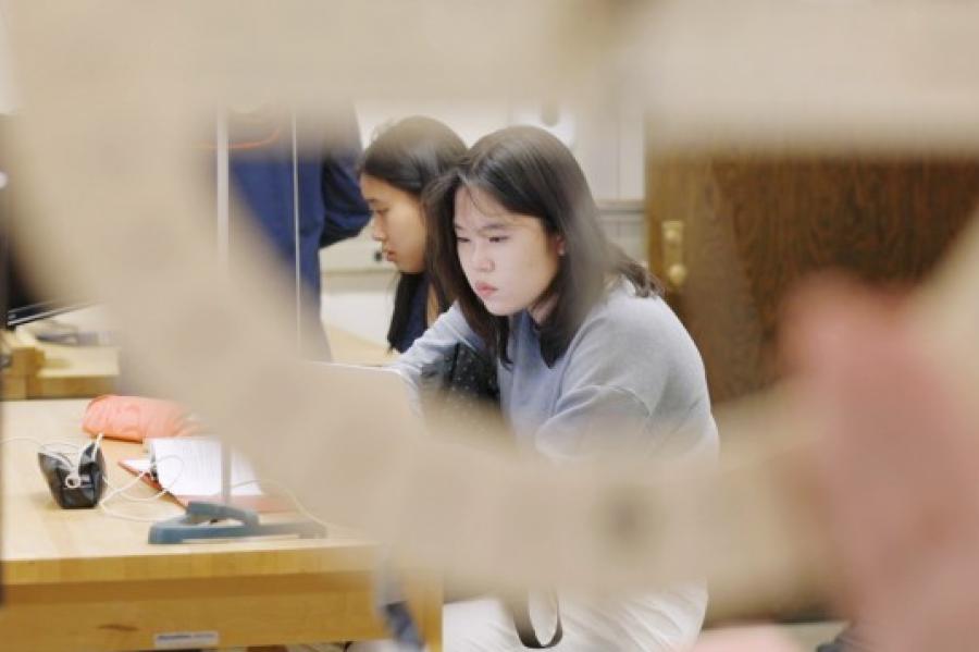 Person looks carefully at physics lab equipment