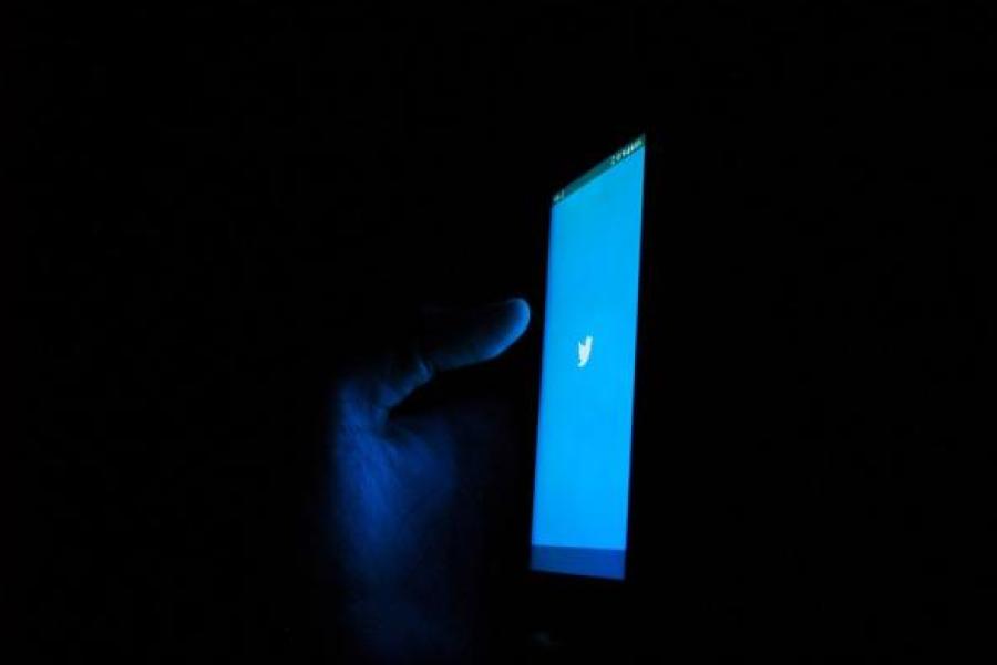 Phone screen showing Twitter logo, dark background