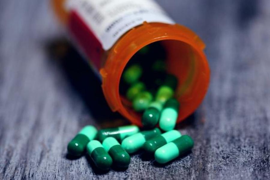 Orange pill bottle, spilling green pills