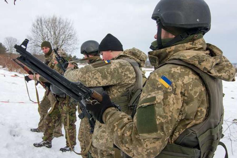 Line of soldiers wearing camouflage, snowy field 