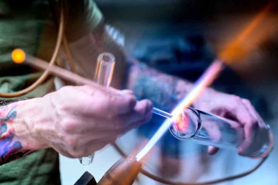 person holding glass to flame