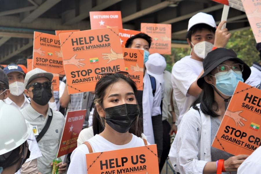 People carrying orange signs in a protest