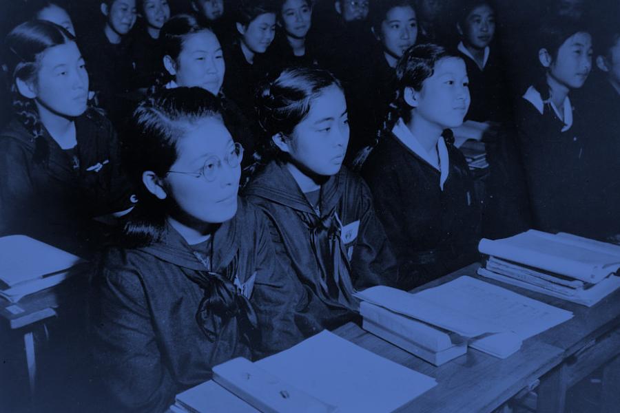 Photograph shows girls seated at desks in newly rebuilt catholic school in Tokyo, Japan.