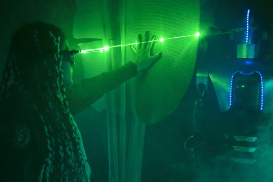 Person wearing bizzare eye gear, bathed in green and blue light