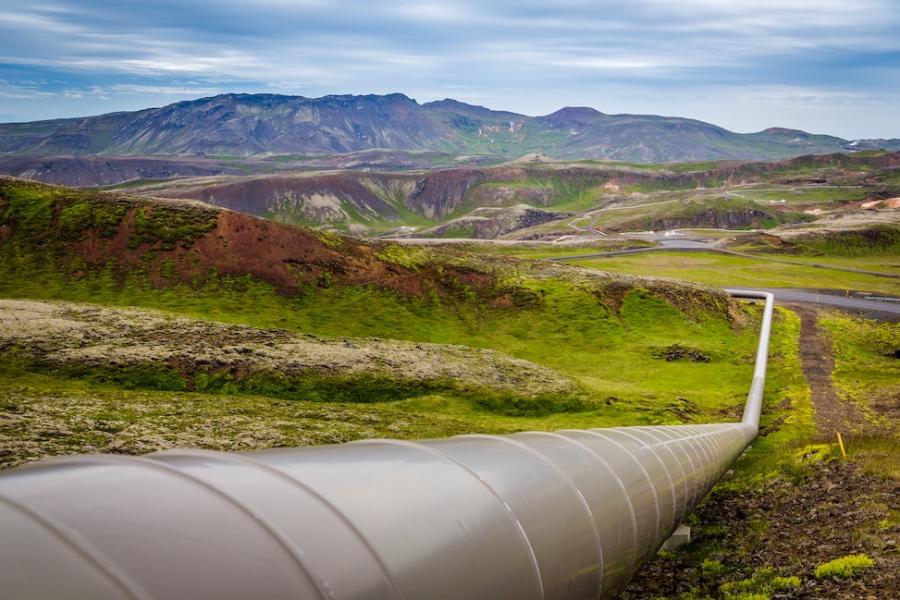 above-ground pipeline extends across a rugged landscape