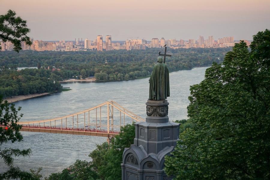 Grey sculpture overlooking river and city