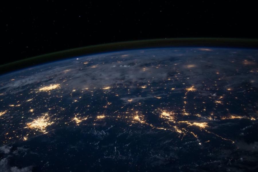 View of Earth from space: dark blue with spots of yellow light