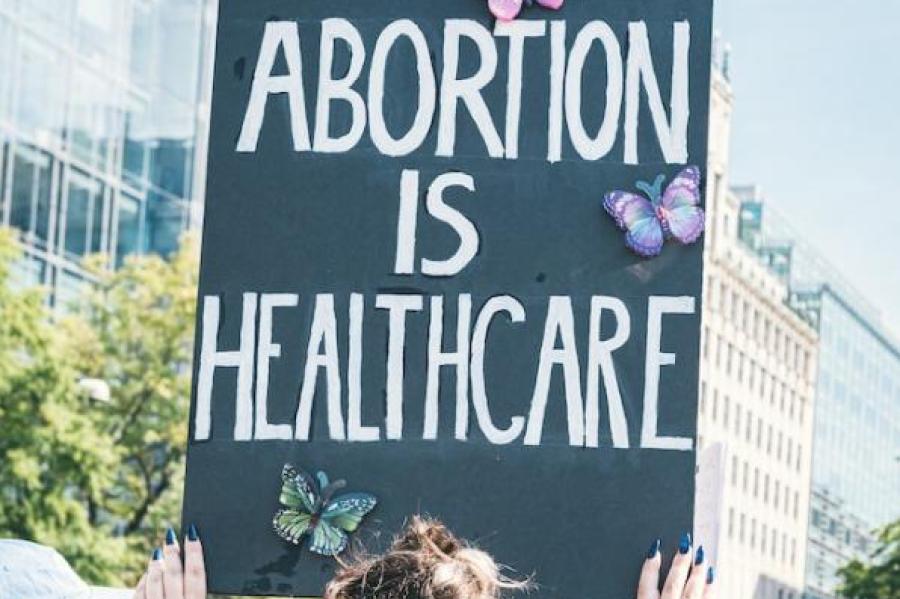 Person holding sign: 'Abortion is Health Care"
