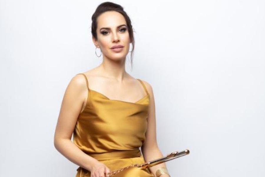 Person sitting on a stool, holding a flute