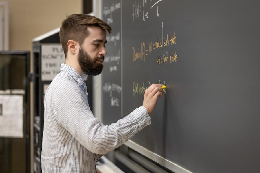 Person writing on a chalkboard