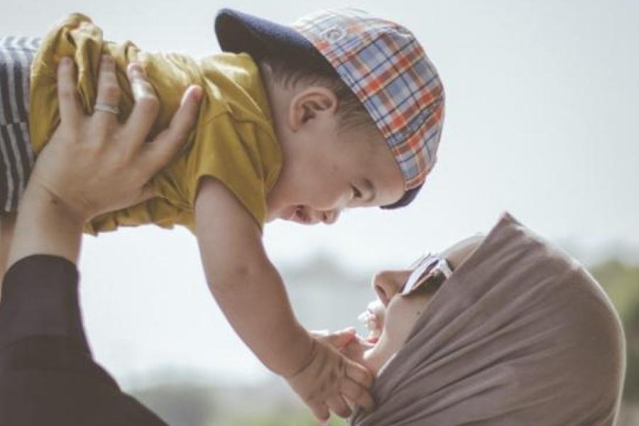 Person holds baby up in the air