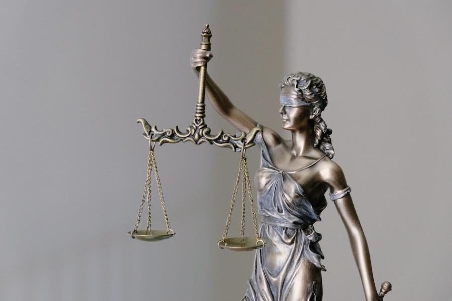 metal sculpture of a figure blindfolded and holding scales