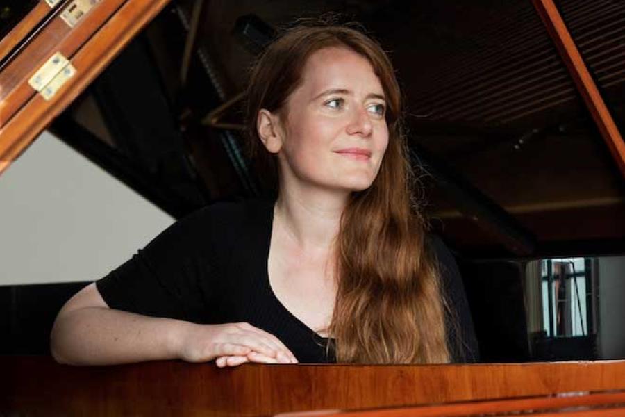 Person posing at a piano