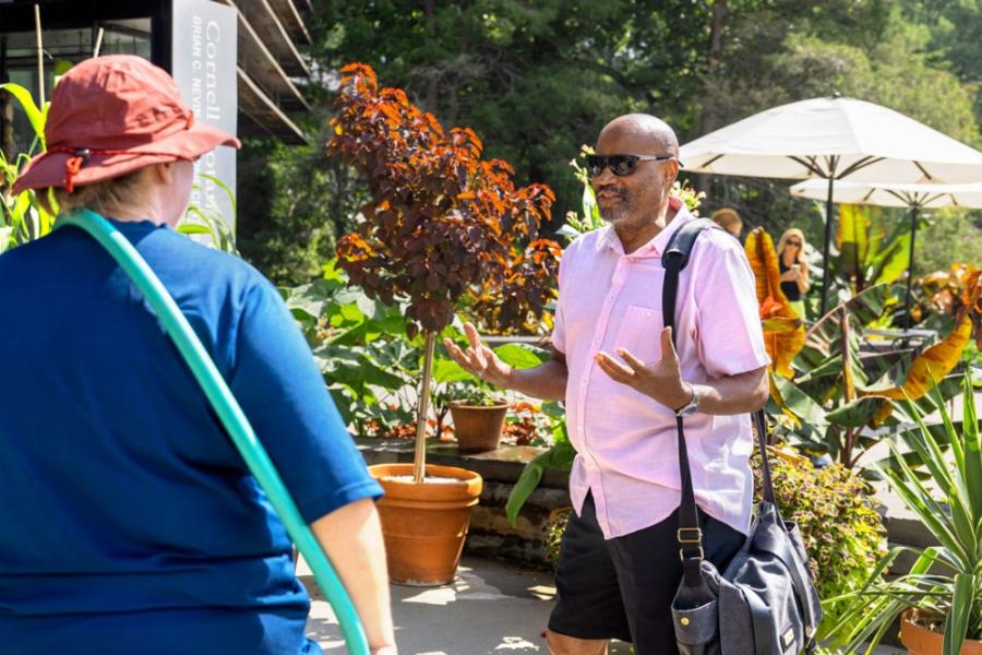 Two people stand in a garden