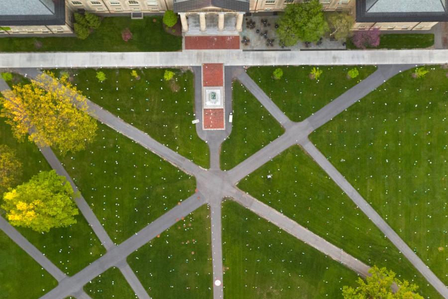 Green lawn intersected by gray paths, seen from the air