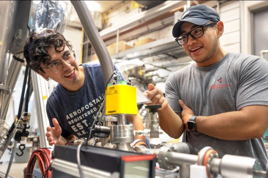 Two people smile, discovering a piece of scientific equipment