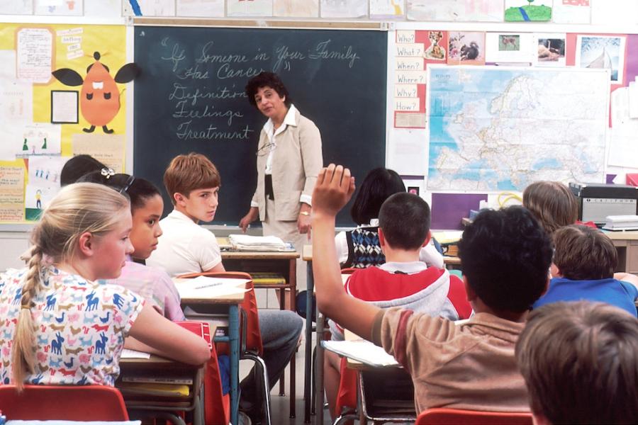 teacher standing at the front of a classroom full of students
