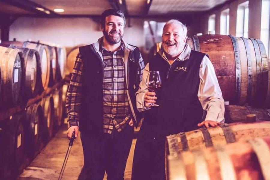 two men by barrels of wine