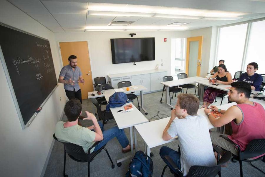 Person speaks in front of a class sitting using dynamic hand gestures