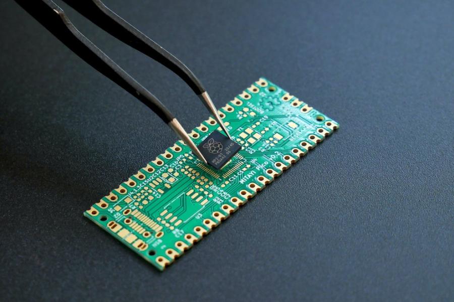 Tweezers placing a black square onto a green rectangle