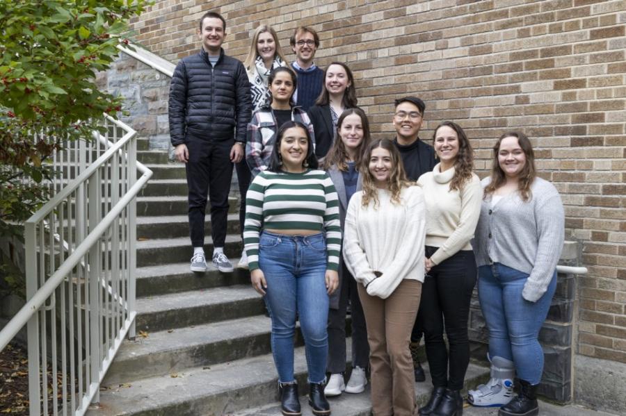 Eleven people pose on a staircase