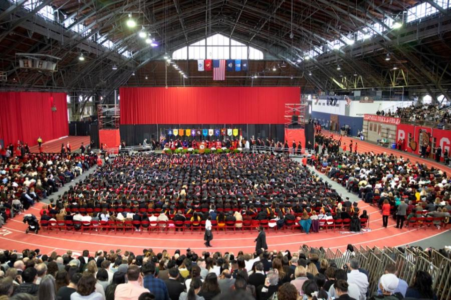 An auditorium with a large crowd celebrating a graduation