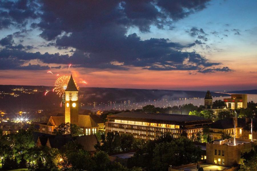 Fireworks burst under a colorful night sky