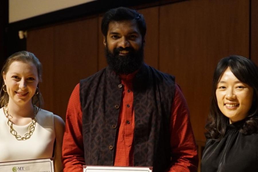 Three people hold certificates