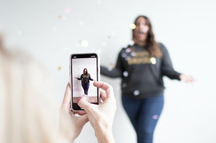 One person films another using a smart phone