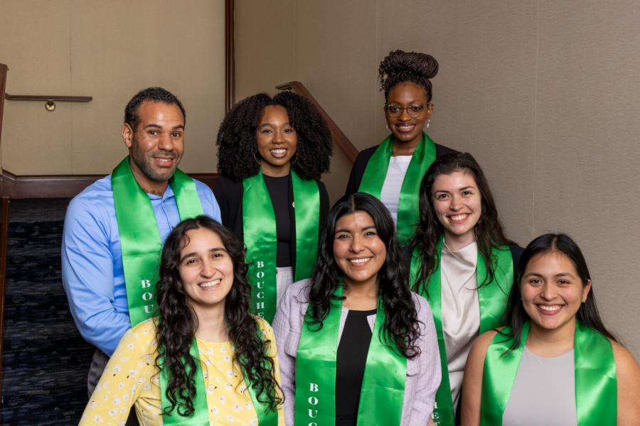 Seven people wearing green honor stoles