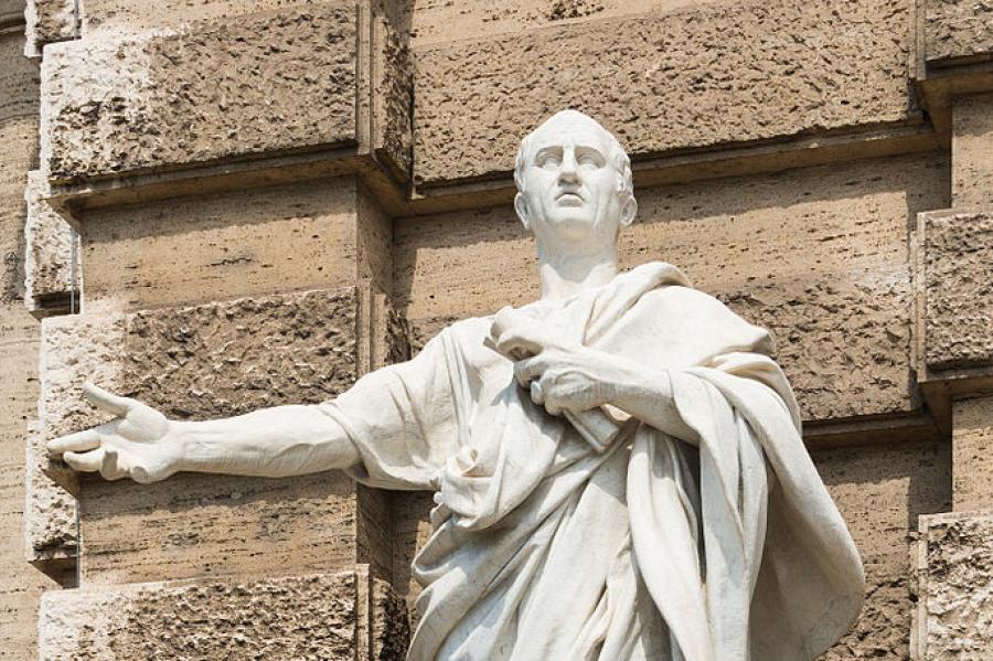 light colored stone statue of a person in a toga, speaking