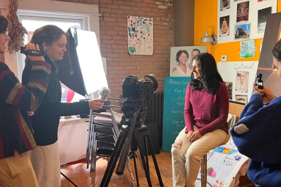 person being filmed and three other people with cameras and audio recording devices