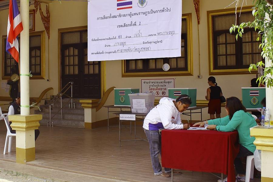 Person leans on a table to write in an office set up outdoors