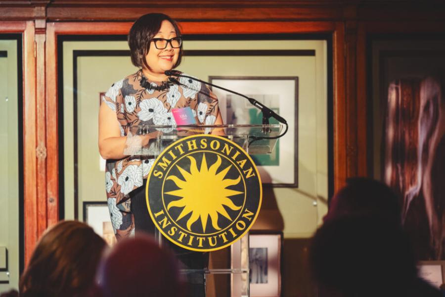 Person standing at a podium with a "Smithsonian Institution" logo
