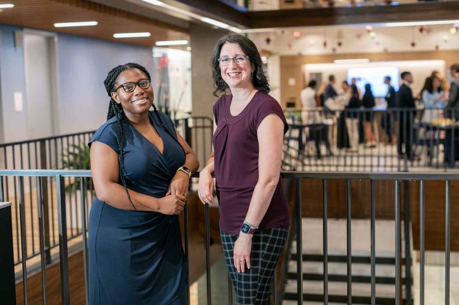 two woman standing at railing