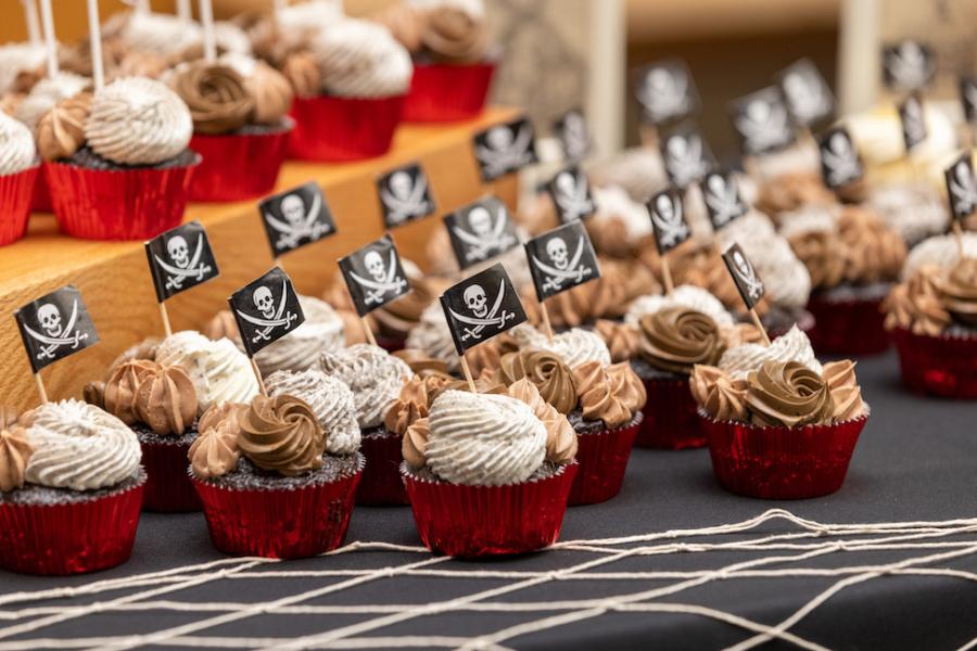 Cupcakes on a table, adorned with pirate flags