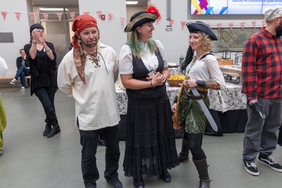 Three people dressed as pirates pose