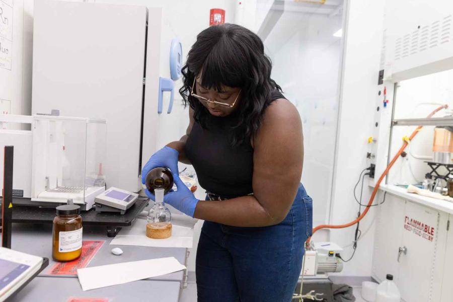 woman pouring chemicals in chemistry lab