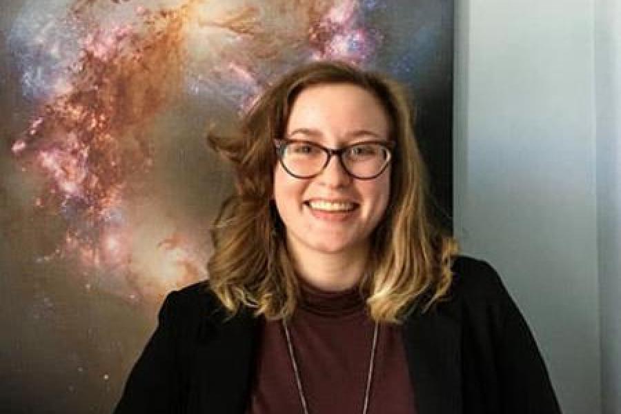 Person standing in front of a poster showing outer space