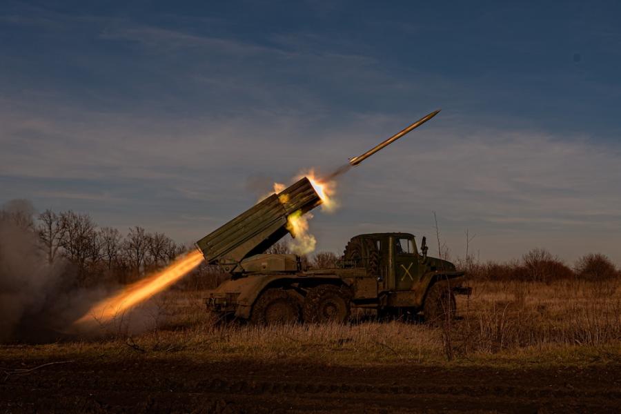 Military vehicle firing a missile while parked in a field