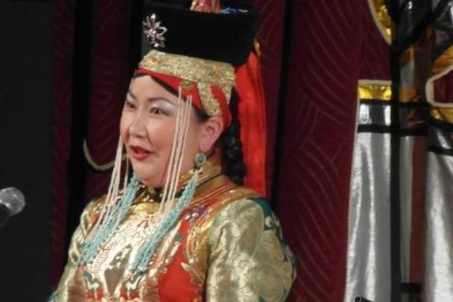 Person singing in a brightly colored traditional costume of Mongolia