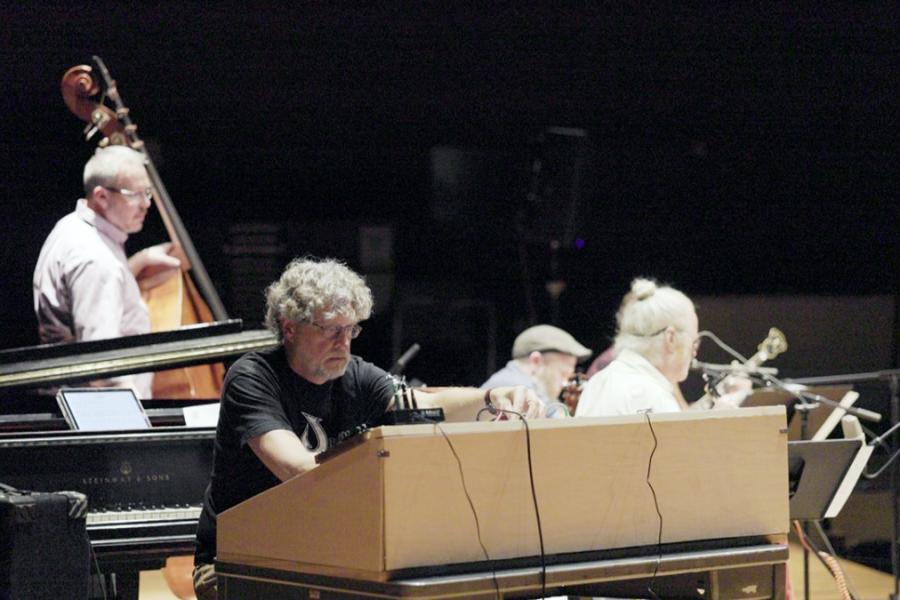 Four people on a stage, with instruments
