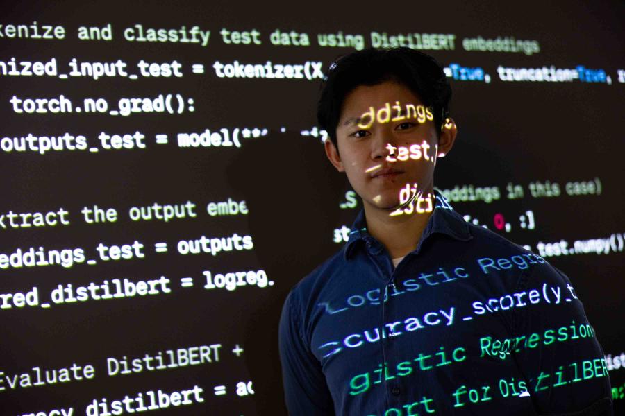 student with text from projector shining on his face