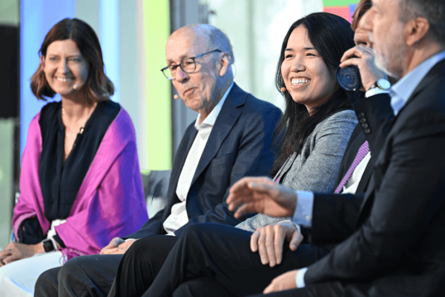 Five people sitting in a row in front of an audience