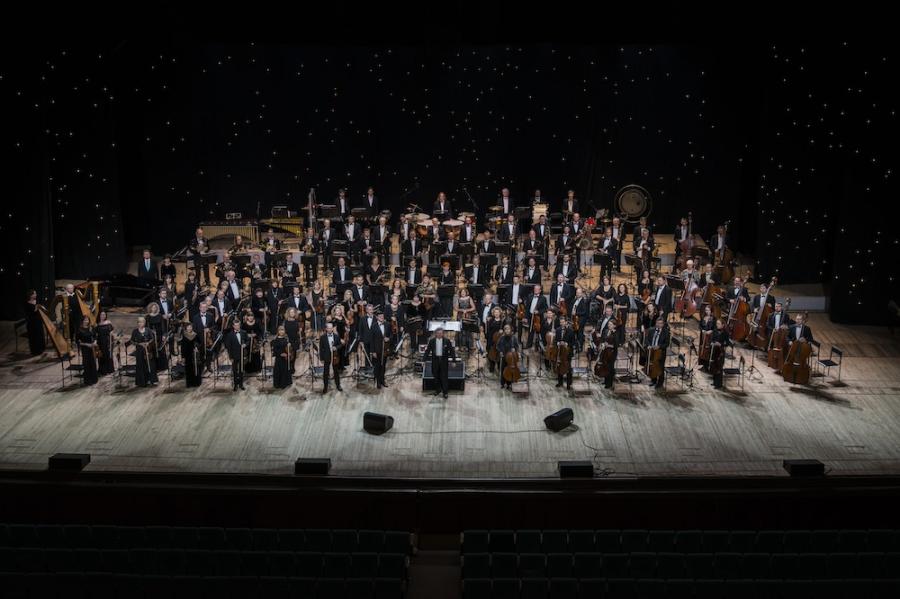Looking down on a stage with a large orchestra arranged on it