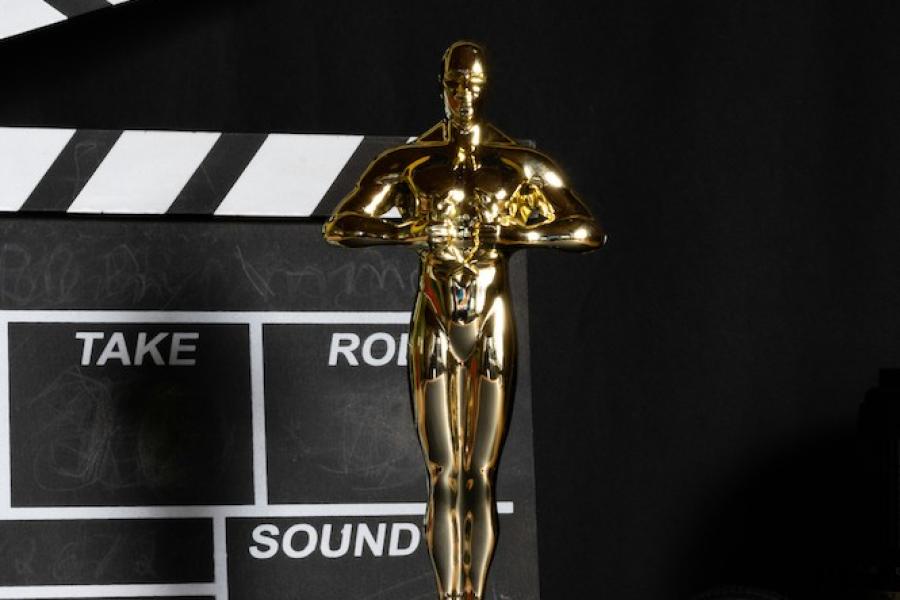 Gold "Oscar" statuette in front of a film take board