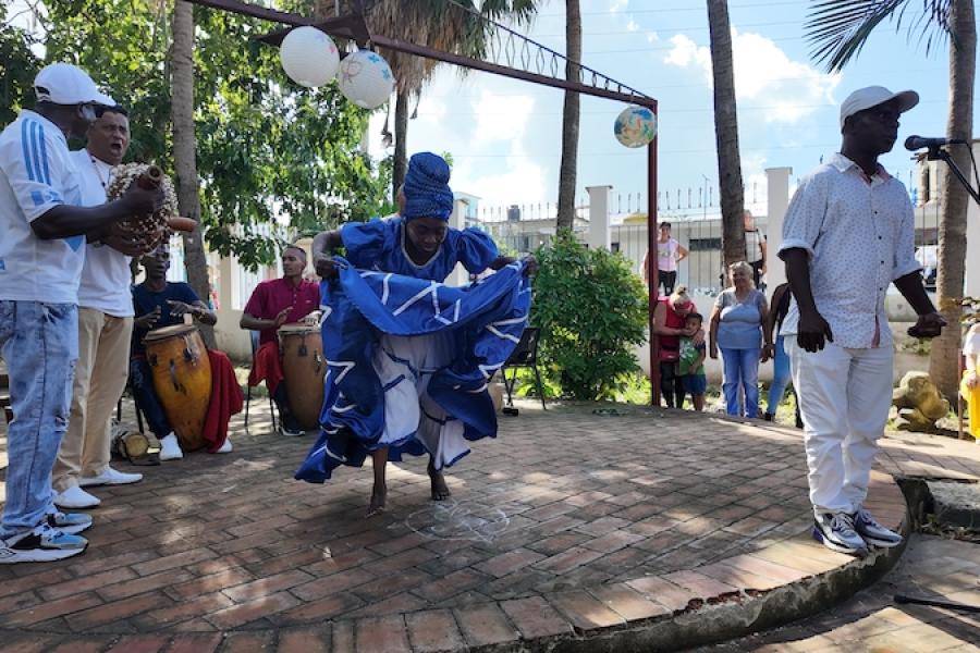 The National Concert Band of Cuba performs on stage with song and dance. 